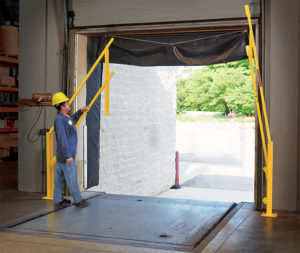 DVG Series low clearance loading dock safety gates being lifted by an employee at an open dock